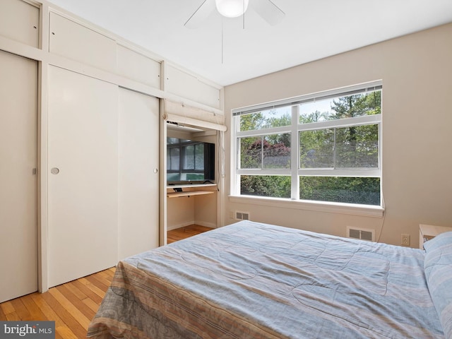 bedroom featuring visible vents, light wood finished floors, ceiling fan, and a closet