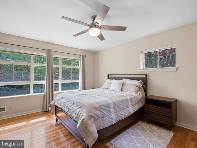 bedroom featuring baseboards, visible vents, ceiling fan, and hardwood / wood-style floors