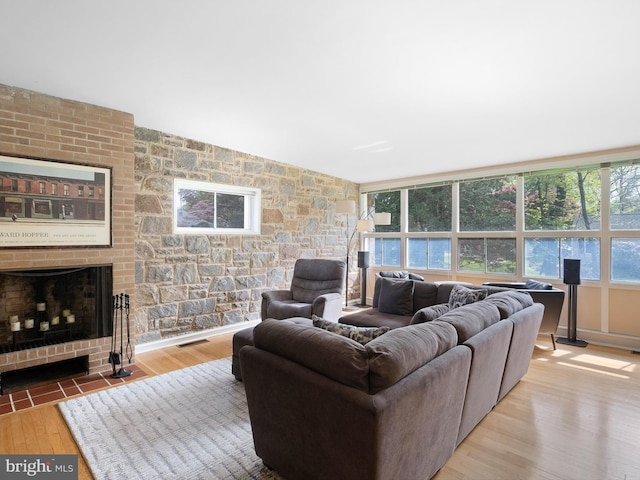 living room featuring a fireplace, wood finished floors, and visible vents