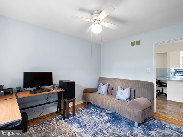 office space featuring visible vents, baseboards, and ceiling fan