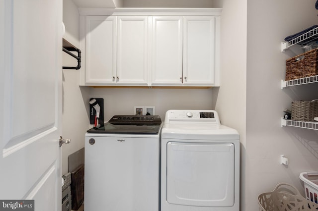 washroom featuring separate washer and dryer and cabinet space