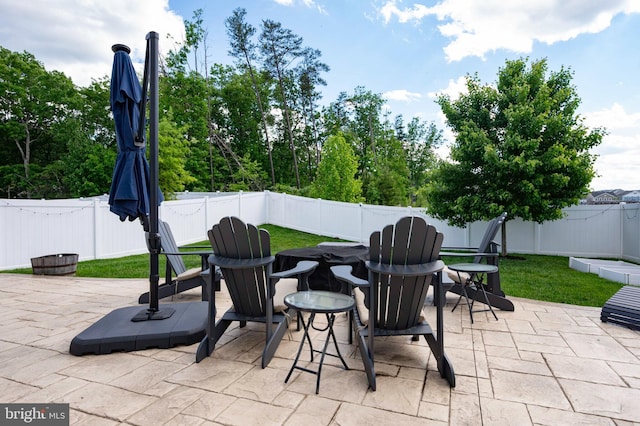 view of patio with a fenced backyard and a fire pit