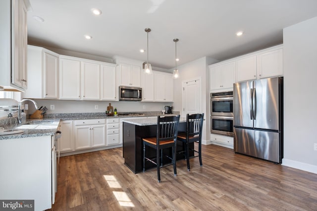 kitchen featuring appliances with stainless steel finishes, dark wood-style flooring, white cabinetry, and recessed lighting