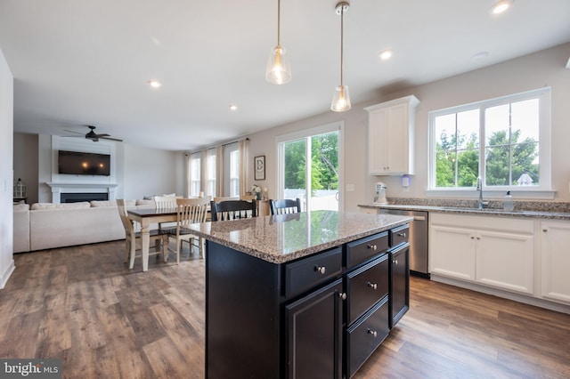 kitchen featuring dishwasher, white cabinetry, a ceiling fan, wood finished floors, and a kitchen island
