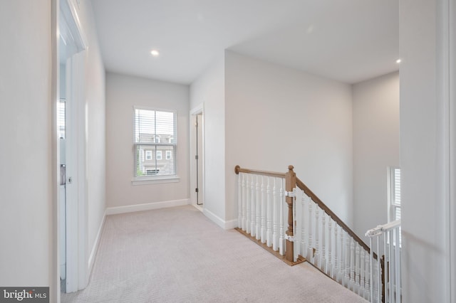 hallway featuring an upstairs landing, carpet, baseboards, and recessed lighting