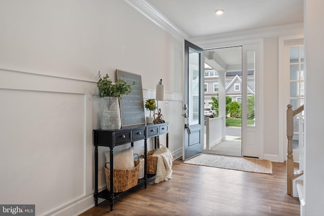 entrance foyer with ornamental molding, wood finished floors, and baseboards