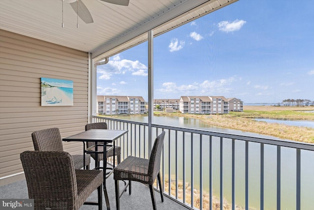 balcony featuring a water view and ceiling fan