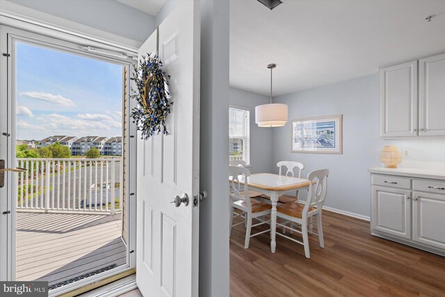 doorway featuring baseboards and wood finished floors