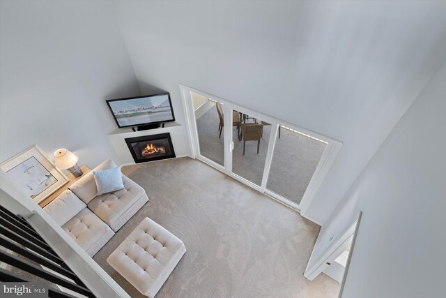 living area featuring carpet floors and a glass covered fireplace