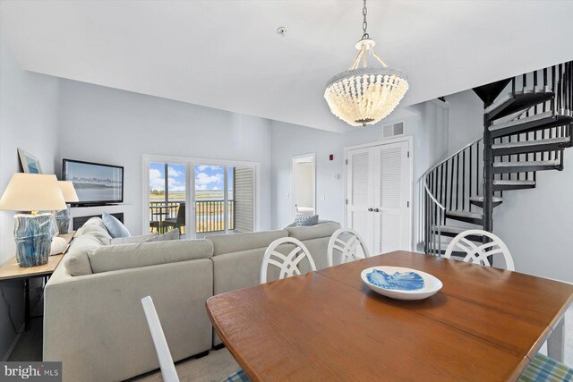 dining space with visible vents, stairs, and a notable chandelier