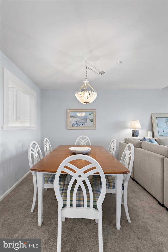 dining space with baseboards and carpet