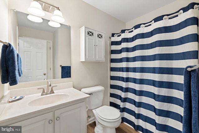 bathroom with vanity, wood finished floors, toilet, and a shower with curtain