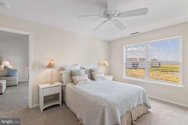 bedroom with baseboards, ceiling fan, visible vents, and light carpet