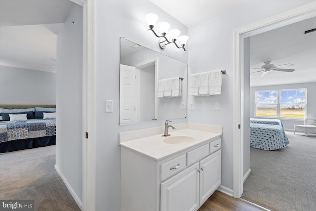 ensuite bathroom with vanity, a ceiling fan, baseboards, and ensuite bath