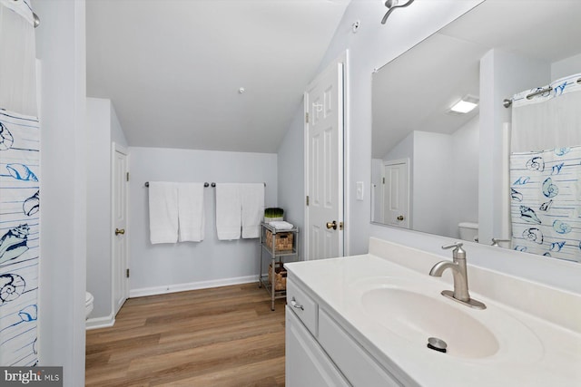 full bathroom with toilet, baseboards, wood finished floors, and vanity