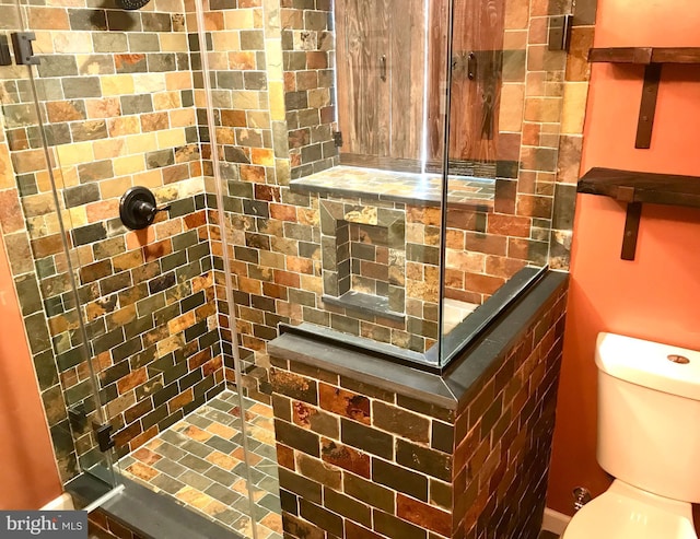 bathroom view of tiled shower and toilet