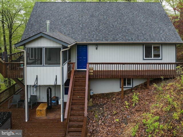 view of front of property featuring stairs, roof with shingles, and a deck