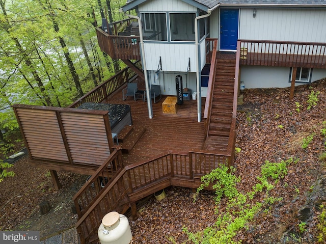 rear view of house with stairway, a deck, and a sunroom