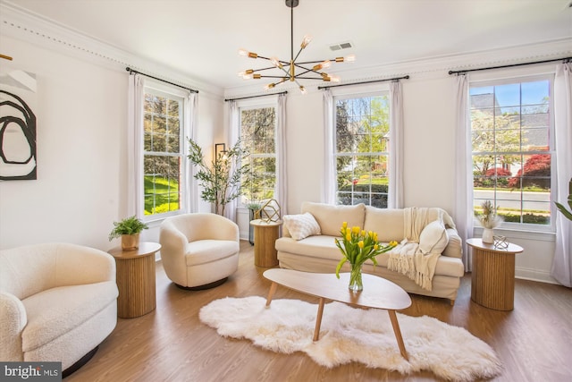 interior space with a chandelier, visible vents, wood finished floors, and a healthy amount of sunlight