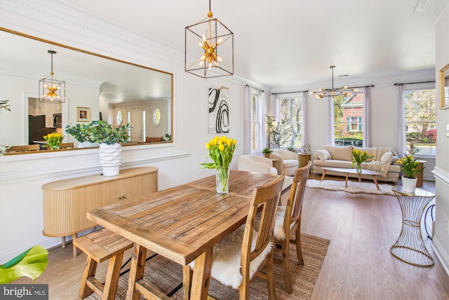 dining area with ornamental molding, wood finished floors, and a chandelier