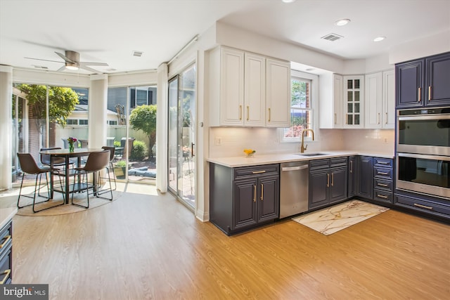 kitchen with a healthy amount of sunlight, appliances with stainless steel finishes, and light wood-style flooring