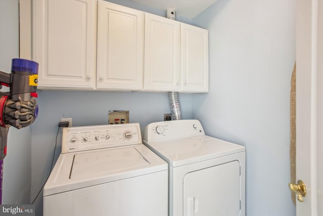 washroom featuring independent washer and dryer and cabinet space