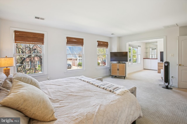 carpeted bedroom with baseboards, visible vents, and multiple windows