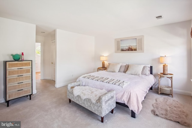 bedroom with baseboards, visible vents, and light colored carpet