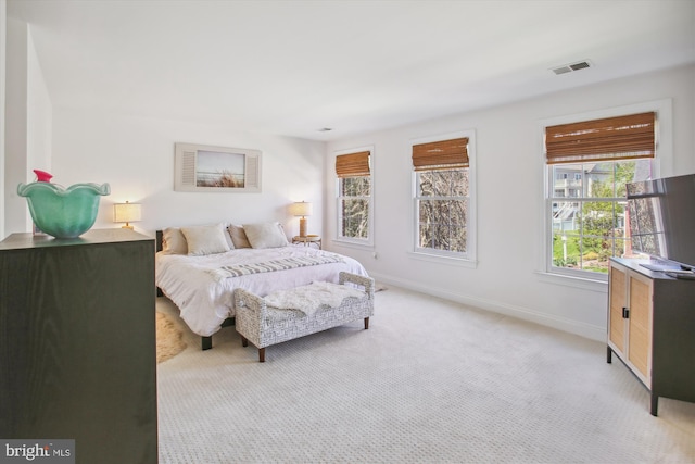 bedroom featuring visible vents, baseboards, and light carpet