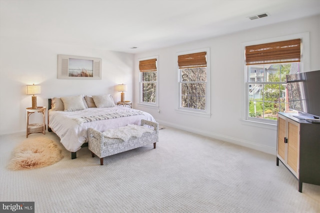 bedroom with visible vents, light colored carpet, and baseboards