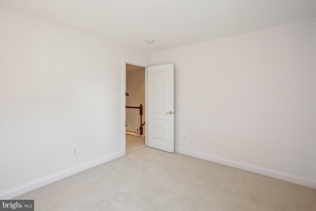 empty room with light carpet and baseboards