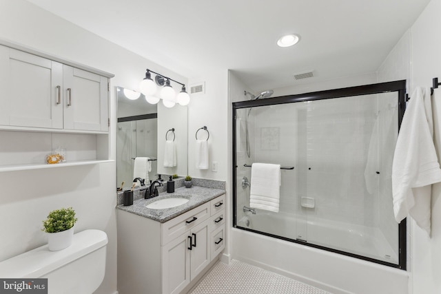 bathroom with toilet, vanity, combined bath / shower with glass door, and tile patterned floors