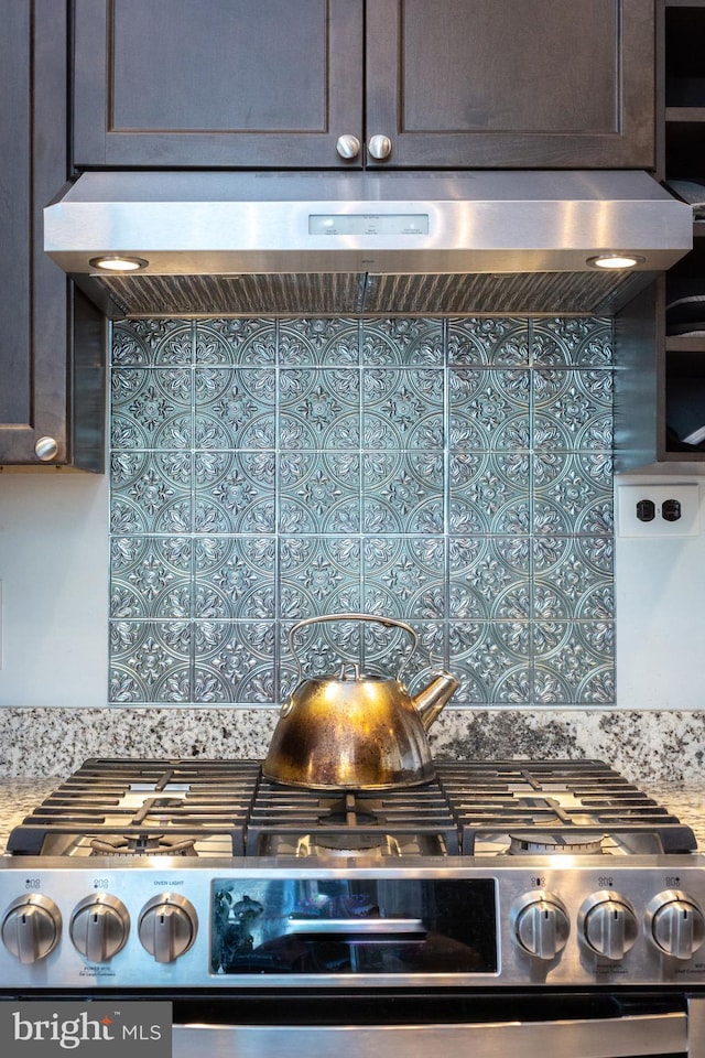 interior details with light stone counters, stainless steel gas range oven, exhaust hood, and dark brown cabinets