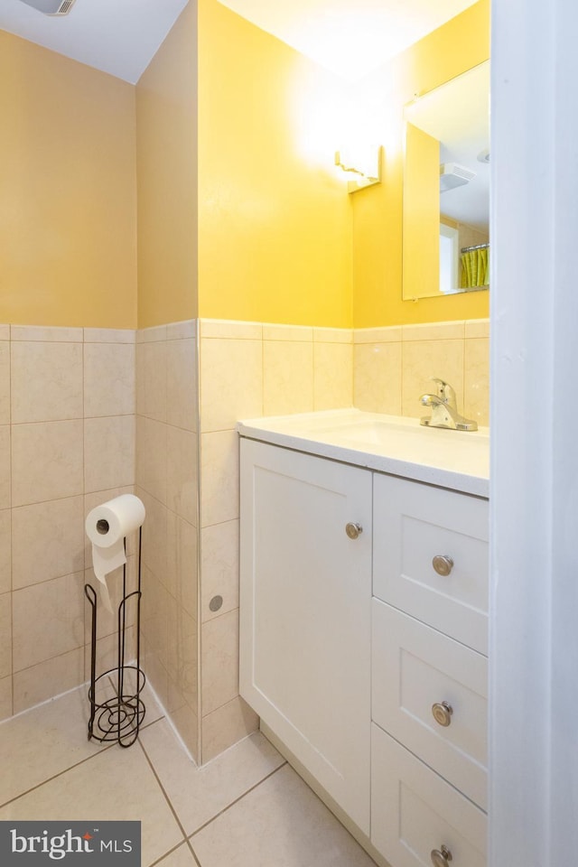 bathroom featuring vanity, tile walls, wainscoting, and tile patterned floors