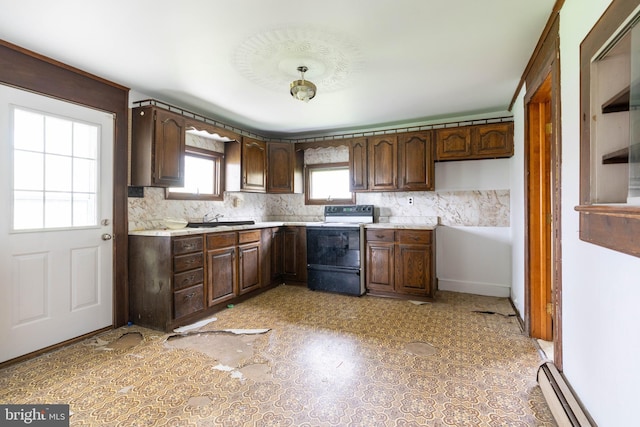 kitchen featuring light countertops, dark brown cabinets, backsplash, electric stove, and a baseboard heating unit