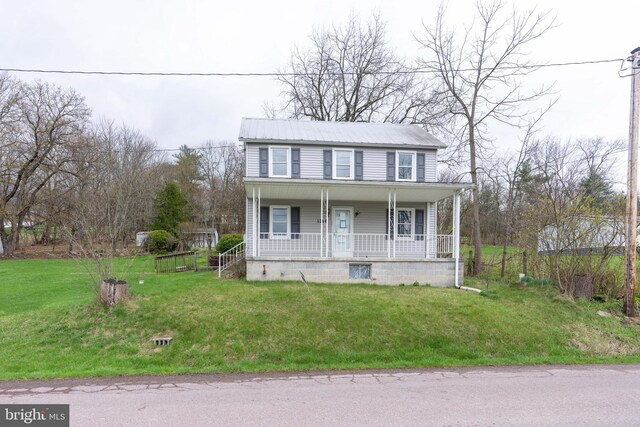 view of front of property featuring a porch, a front yard, and metal roof