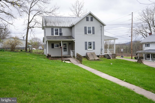 rear view of property featuring a yard and metal roof