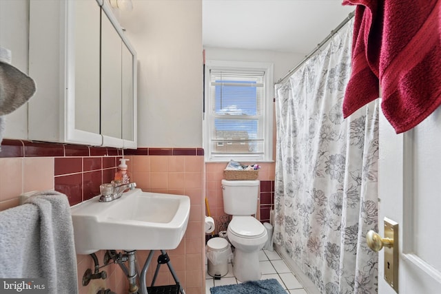 bathroom with tile walls, tile patterned flooring, a shower with shower curtain, and toilet