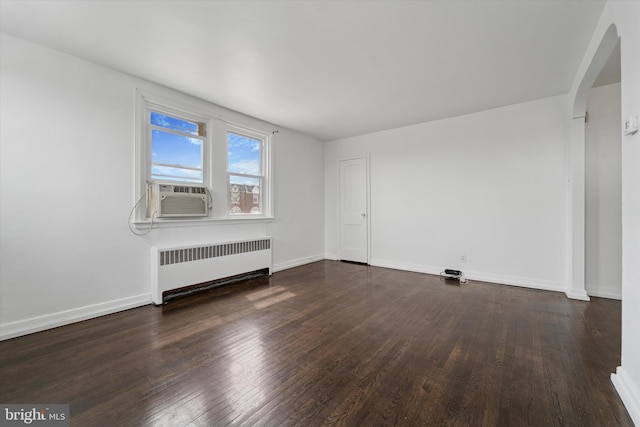 interior space featuring arched walkways, radiator heating unit, wood finished floors, and cooling unit