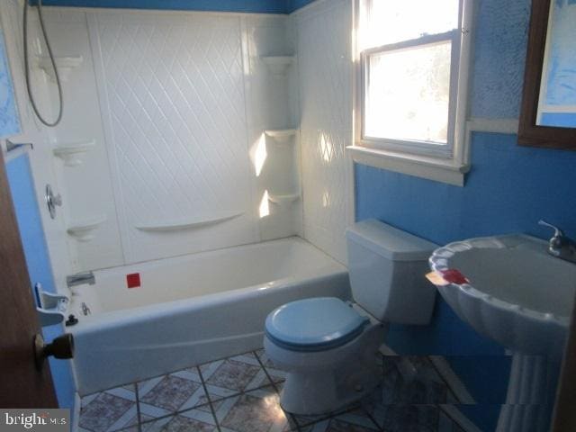bathroom featuring toilet, a sink, and  shower combination