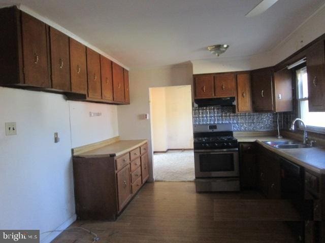 kitchen with stainless steel range with gas cooktop, a sink, decorative backsplash, light countertops, and under cabinet range hood