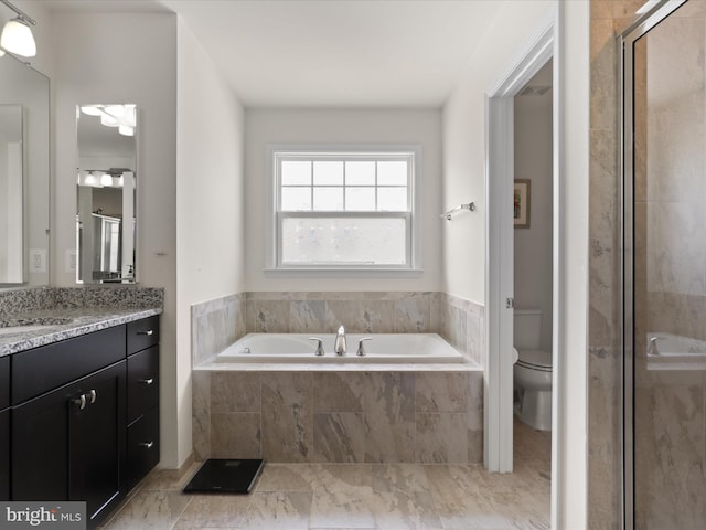 full bathroom featuring a shower stall, a garden tub, toilet, and vanity