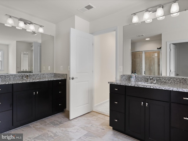 bathroom featuring two vanities, visible vents, a stall shower, and a sink
