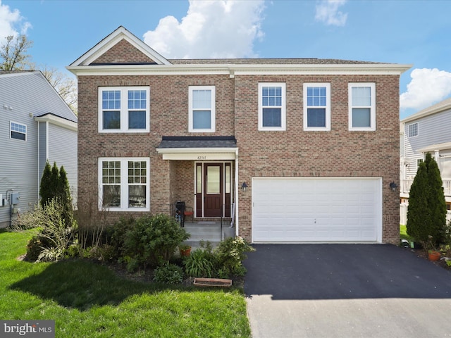 view of front of home with a front lawn, driveway, brick siding, and a garage