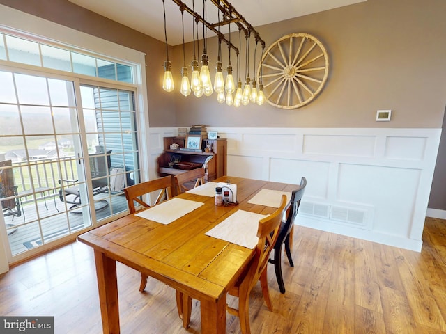 219 Pepper Ridge Dr, Spring Mills, PA 16875 - dining area with visible vents, a decorative wall, a wainscoted wall, and light wood-style flooring