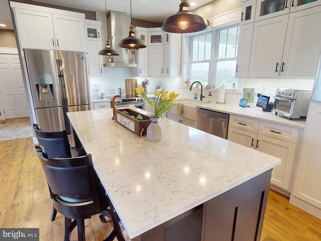 219 Pepper Ridge Dr, Spring Mills, PA 16875 - kitchen with light stone countertops, appliances with stainless steel finishes, white cabinets, light wood finished floors, and a sink