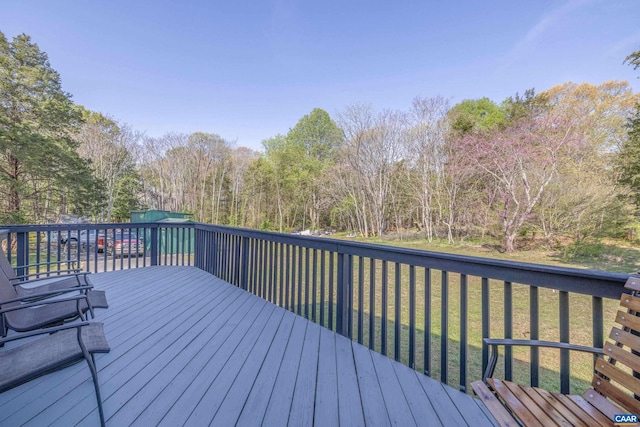 wooden deck featuring a lawn