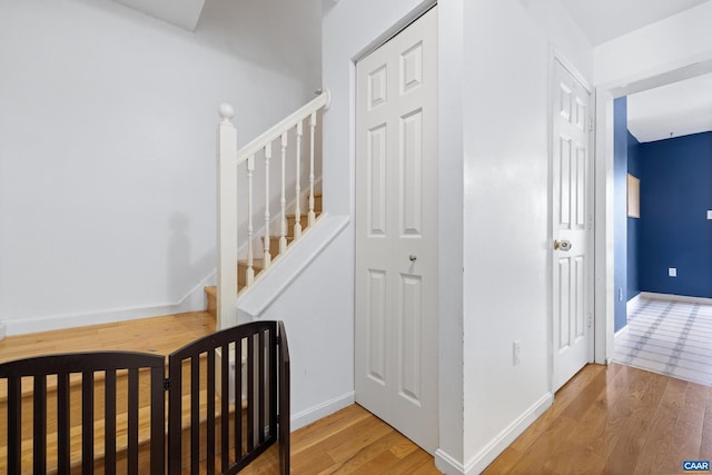 staircase featuring baseboards and wood finished floors