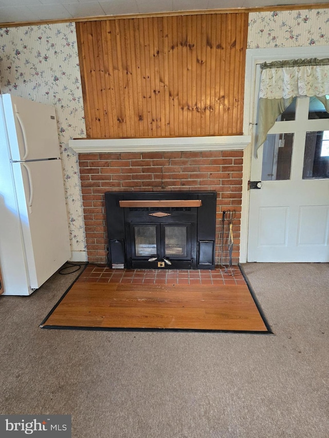 13177 Main St, Fort Loudon, PA 17224 - room details with freestanding refrigerator, carpet, a brick fireplace, and wood walls