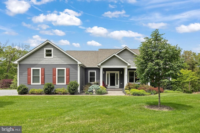 view of front facade with a front yard and roof with shingles